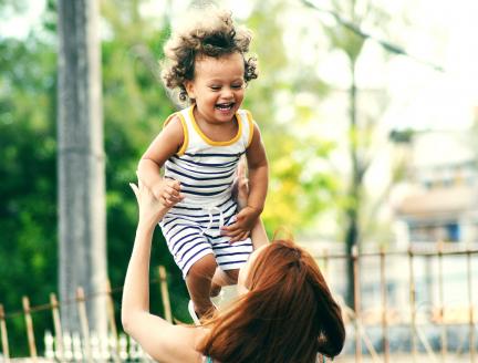 Woman holding her happy baby up