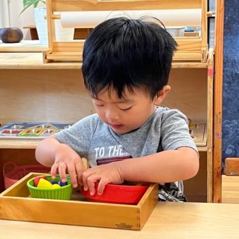 Child preparing snack cutting fruit at Lifetime Montessori School in San Diego